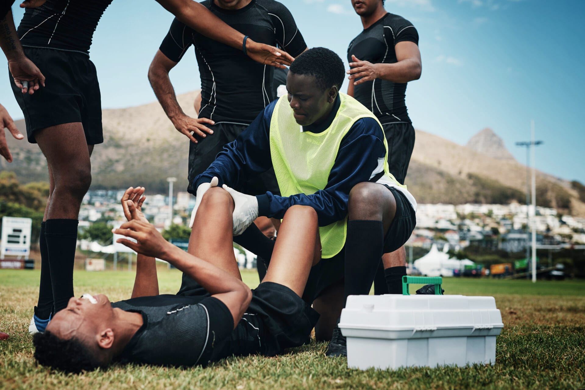 Cropped shot of a young rugby player receiving first aid assistance on the field.